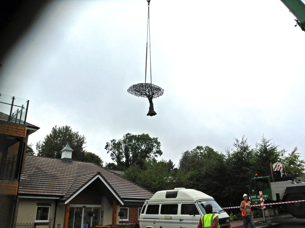 Arbour Metallum monumental tree sculpture commission being lifted over the roof of a hospital by Mark Reed